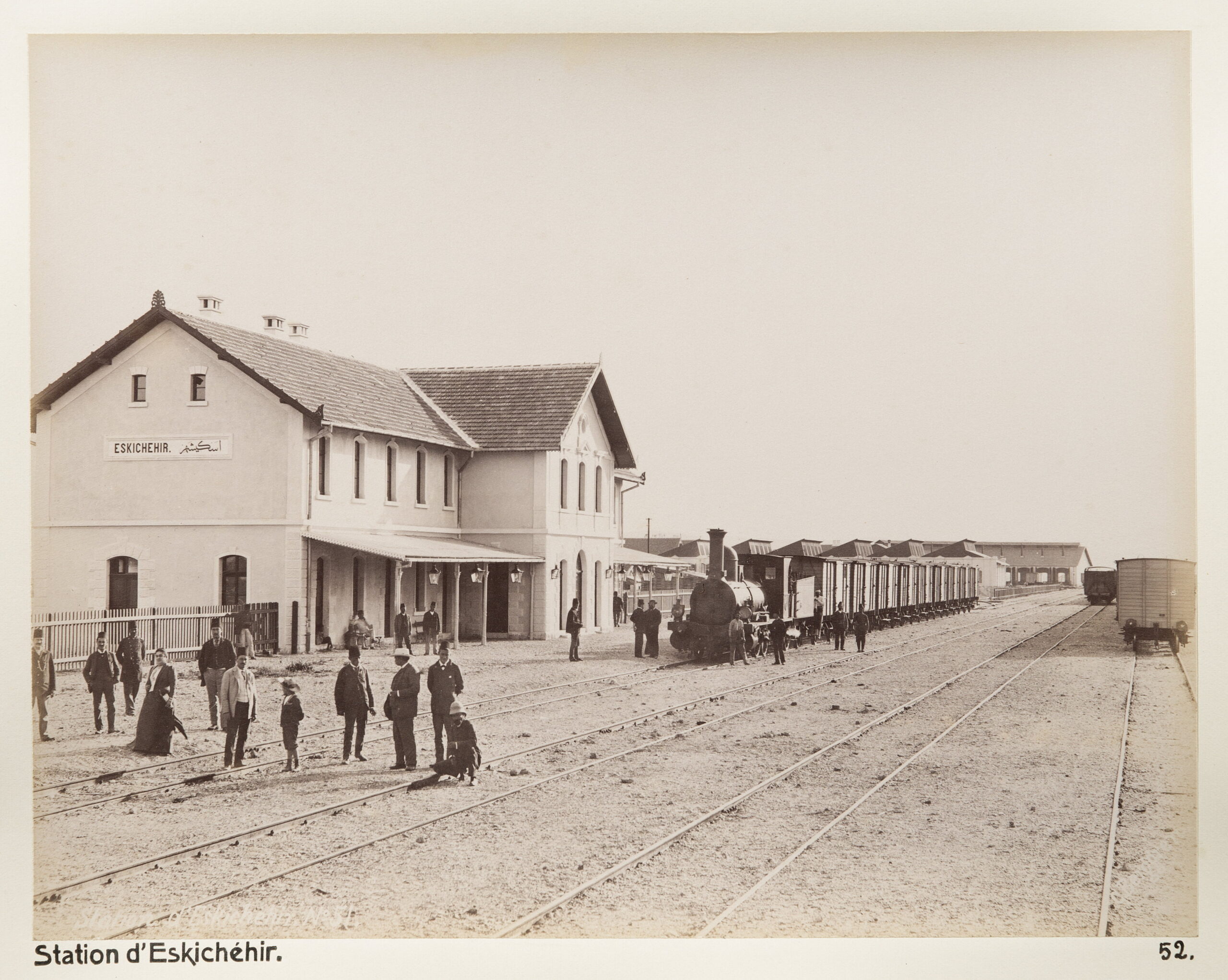 Stationen i Eskisehir. Text på originalet: “Station d´Eskichéhir.”

Fotografierna LXVI:O.01.-54. kommer från resan till Turkiet och Mindre Asien som Wilhelmina och Walther von Hallwyl gjorde den 27 april – 20 juni 1901. De lämnade Sverige den 5 november 1900 för Egypten, där de stannade till den 28 mars 1901, då de fortsatte till Palestina. Den 27 april fortsatte de till Turkiet och Mindre Asien. Med på resan var Wilhelminas sällskapsdam, fröken Ida Uhse. I Konstantinopel (Istanbul) anslöt sig Wilhelminas mor Johanna Kempe och kusindottern Elma Hök.

Fotografierna är inköpta av Wilhelmina i Konstantinopel (Istanbul) och Brussa.

Alla uppgifter kommer från Ida Uhses reseanteckningar.